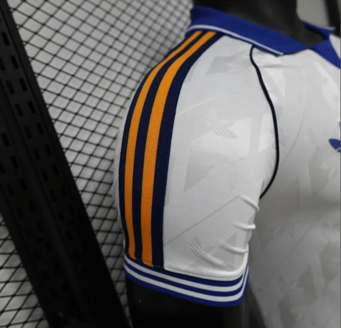 Side view of white Real Madrid jersey with blue and yellow stripe accents