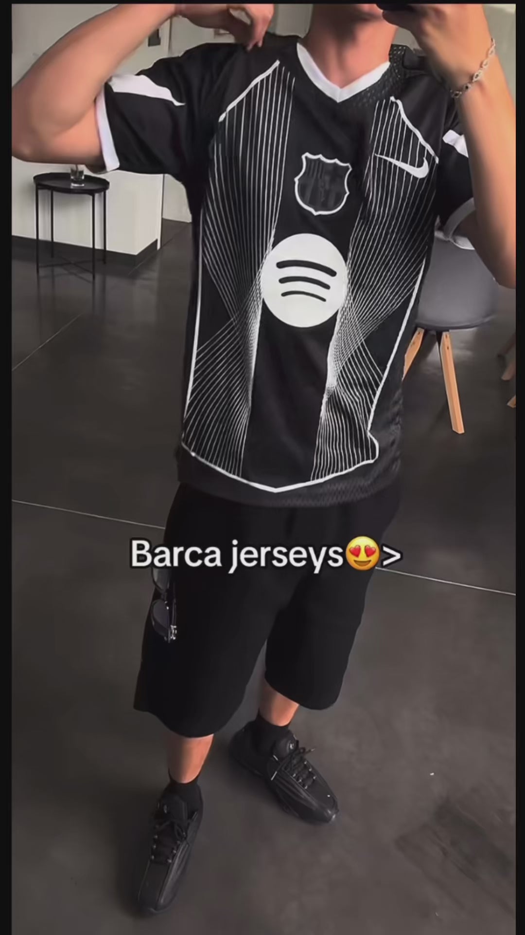Person wearing black Barcelona jersey with logo and stripes